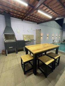 Casa Valentina em Milagres - AL في ساو ميغيل دوس ميلاجريس: مطبخ مع طاولة وكراسي خشبية وفرن