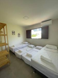 Habitación con 4 camas y ventana. en Casa Valentina em Milagres - AL, en São Miguel dos Milagres