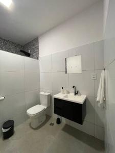 Un baño blanco con inodoro y lavabo. en Casa Valentina em Milagres - AL, en São Miguel dos Milagres