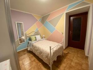 um quarto com uma cama com uma parede pintada em Ca’Lina,autentico alloggio spazioso con posto auto em Lecco