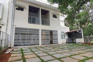 a white house with a gate in front of it at SS Lumina Villa in Bengaluru +10 photos