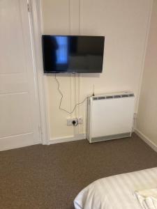 a room with a tv on the wall and a radiator at Town House 8-8A High Street in Newport