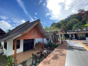a house with a deck with chairs and tables at Sunrise House in Ko Yao Noi