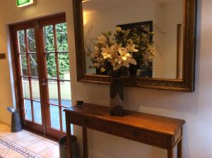 a vase of flowers on a table under a mirror at Browns Boutique Hotel in Queenstown