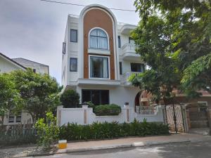a white house with a fence and trees at Seaside Villas An Vien Nha Trang in Nha Trang