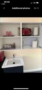 baño con lavabo blanco y maleta roja en Self contained room, en-suite with separate lockable front door, located in an exclusive area en Wednesbury