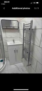 a white bathroom with a sink and a shower at Self contained room, en-suite with separate lockable front door, located in an exclusive area in Wednesbury