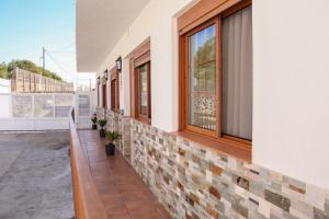 a building with a brick wall and windows at Mary (A): Confort y playa. in Breña Baja