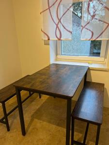 a wooden table and a bench in front of a window at Apartment in Stadtzentrum Oelsnitz in Oelsnitz