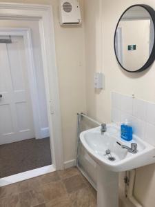 a bathroom with a sink and a mirror at Town House 8-8A High Street in Newport