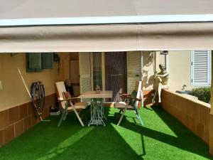 een patio met een tafel en stoelen op het gras bij Casa Coquina. Vera Natura. Urbanizacion naturista in Vera