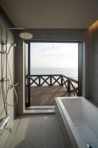 uma casa de banho com banheira e vista para o oceano em Nesoberi　VILLA TAKASU em Kanoya