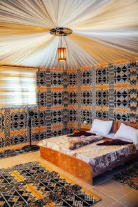 ein Schlafzimmer mit einem Bett und einer Wand mit Fliesen in der Unterkunft Rum Under The Stars Camp in Wadi Rum
