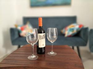 a bottle of wine and two wine glasses on a table at Cambrils Happy Place in Cambrils