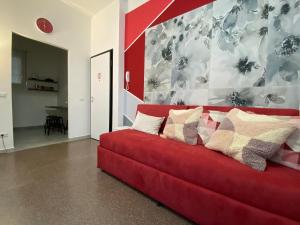un sofá rojo con almohadas en la sala de estar en My Red at Milano Mind, en Pero