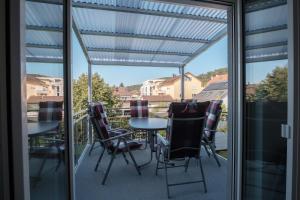 a patio with a table and chairs on a balcony at Neusaniertes 3Familienhaus am Bahnhof Wyhlen 7Min von Basel CH in Grenzach-Wyhlen