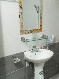 uma casa de banho com um lavatório branco e um espelho. em New Homestay em Ha Giang