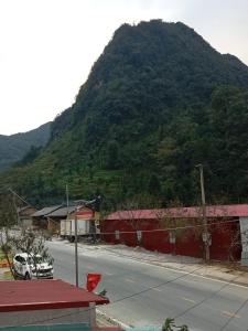 una strada di fronte a una montagna con una strada di New Homestay a Ha Giang