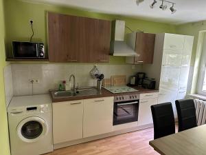 a kitchen with a sink and a washing machine at Ferienwohnung, Apartment, Monteurwohnung mit Klimaanlage Wettin - Löbejün 