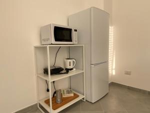 a white refrigerator and a microwave on a shelf at My Blue at Milano Mind in Pero