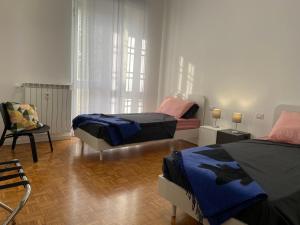 een slaapkamer met 2 bedden en een stoel bij My Blue at Milano Mind in Pero