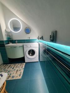 een badkamer met een wasmachine en een wastafel bij BeachHouse Ischia in Ischia