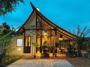 a house with a large roof with a patio at O2 The Residence โอทู เดอะ เรสซิเดนซ์ in Kanchanaburi
