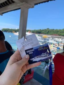 een persoon die een ticket voor een cruiseschip vasthoudt bij GiliFerries Semaya One Cruise in Padangbai