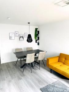 ein Esszimmer mit einem Tisch, Stühlen und einem Sofa in der Unterkunft Zollernalb-Apartment G6 in Albstadt