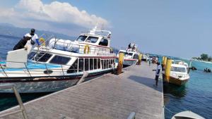 GiliFerries Semaya One Cruise في بادانجباى: يتم رسو مركبين في مرسى في الماء