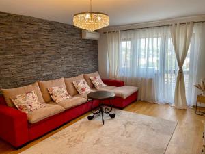 un soggiorno con divano rosso e muro di mattoni di Apartament 1 camera, zona centrala a Iaşi