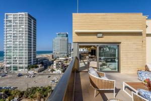 a balcony with chairs and a view of a city at #Breathtaking 4BR/3BA Duplex Seafront in Tel Aviv