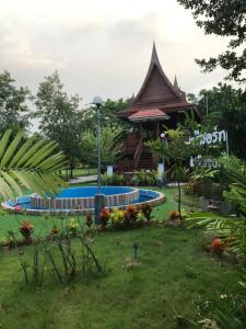 a garden with a gazebo and a swimming pool at Sripiamsuk Resort Bangkok in Pathum Thani