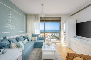 un soggiorno con divano blu e TV di #Breathtaking 4BR/3BA Duplex Seafront a Tel Aviv