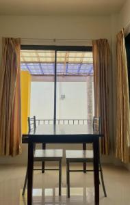 una mesa y dos sillas frente a una ventana en บ้านพักสิริ มุกดาหาร (Baan Siri Mukdahan) en Ban Muang Ba