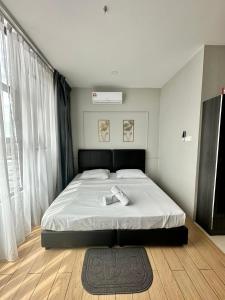 - une chambre avec un grand lit et des draps blancs dans l'établissement Manhattan Suites by NAJ, à Penampang