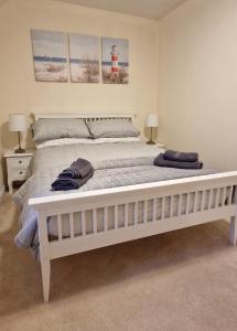 a large white bed in a bedroom with two lamps at Two bedroom character cottage in Rhuddlan