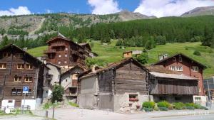 a group of buildings in front of a mountain at Le Charlot in Saas-Grund