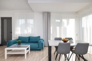 uma sala de estar com um sofá azul e uma mesa em Villa Tonći Zaton em Zaton