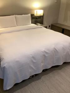 A bed or beds in a room at Jin Shi Hu Hotel