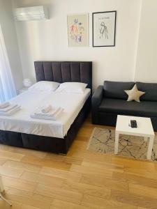 ein Schlafzimmer mit einem Bett und einem Sofa in der Unterkunft Apartman PORTO in Trebinje