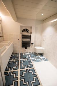 a bathroom with a blue and white tile floor at Friesenhaus am See in Aventoft +6 photos