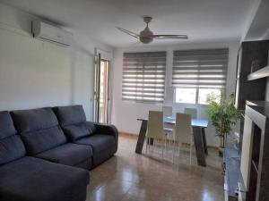 a living room with a blue couch and a table at Apartamento Playa de Xilxes. in Moncófar