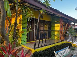 una casa amarilla y verde con un banco delante en บ้านพักสิริ มุกดาหาร (Baan Siri Mukdahan), en Ban Muang Ba