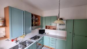 uma cozinha com armários verdes e um lavatório em Casa Parco Leati em Ferrara