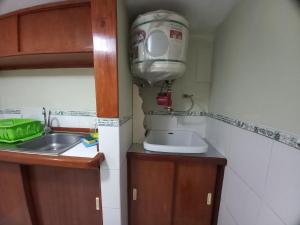 una pequeña cocina con fregadero y aire acondicionado en Miraflores Departamentos, en Lima