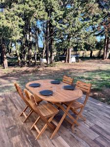 une table en bois avec deux chaises dans l'établissement Maisonnette avec petite forêt, à Valréas