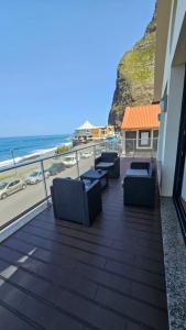 d'un balcon avec des chaises et une vue sur l'océan. dans l'établissement Ocean Breeze Apartment, à São Vicente