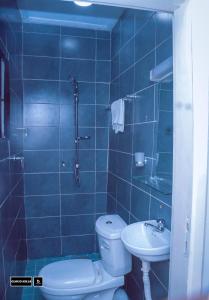 Baño de azulejos azules con aseo y lavamanos en CloudHill en Buea