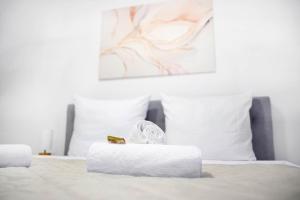 a white bed with two white pillows and a box on it at IDEE living:Loft-Apartment bei Heidelberg in Dossenheim